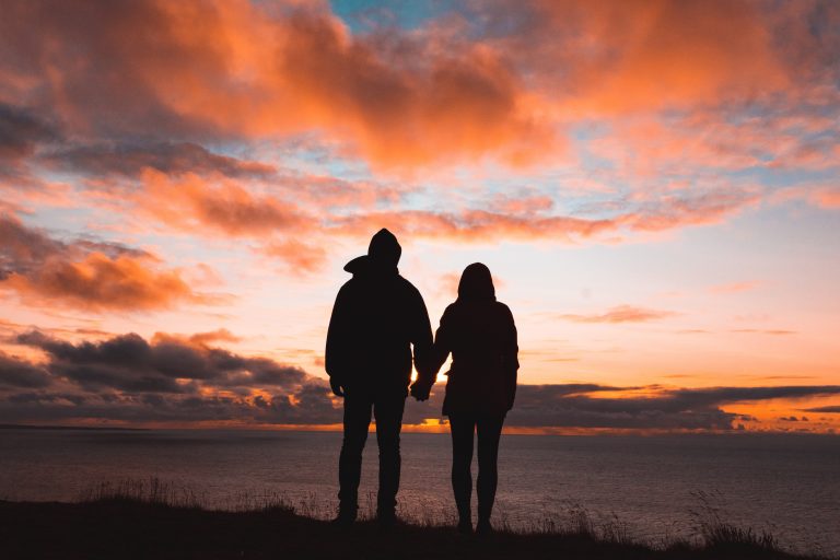 Couple holding hands during sunset